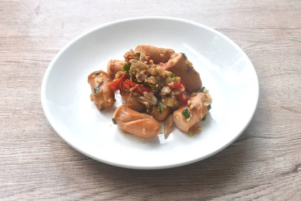 Kızarmış tuzlu sosis, sarımsak ve tabakta kırmızı biber. 