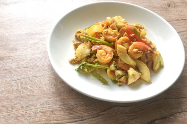 Karıştırılmış baharatlı kalamar karides tuzlu yumurta ve tabakta sos.