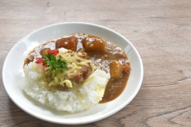 Sade pirinç soslu patates ve Japon köri soslu havuç üzerine kızarmış domuz hamburgeri bifteği. 