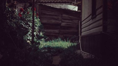 Ahırdan ahşap bir duvarı aşan dar bir yol.