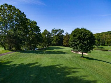 New England Golf Sahası yeşil çizgili ağaçlara yaklaşıyor