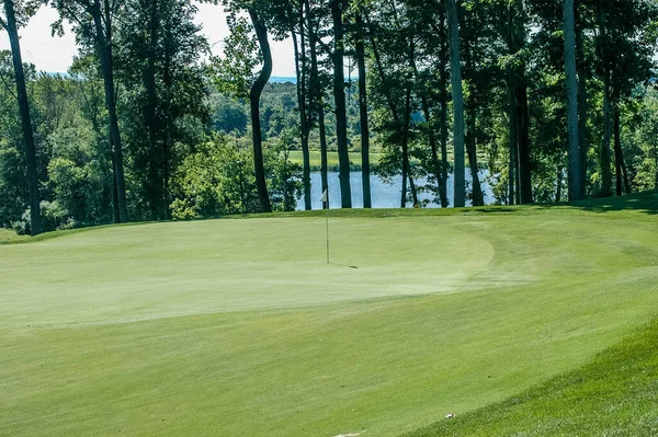 背景に池とゴルフグリーン — ストック写真