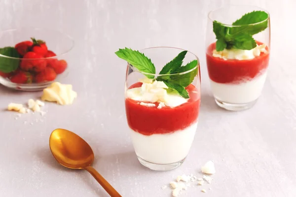 Jogurtový dezert s jahodovou kaší a merengue ve dvou sklenicích na světle šedém pozadí — Stock fotografie