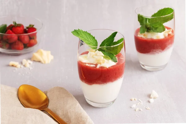 Jogurtový dezert s jahodovou kaší a merengue ve dvou sklenicích na světle šedém pozadí — Stock fotografie