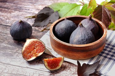 Köy arka planında taze incir dolu ahşap bir kase.