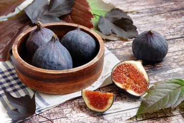 Köy arka planında taze incir dolu ahşap bir kase.