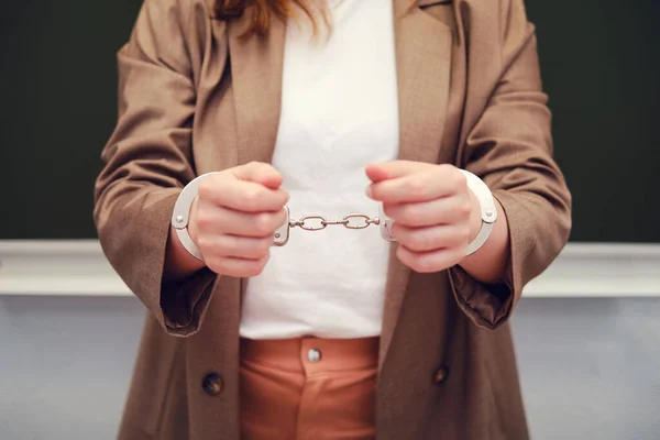Woman in handcuffs, concept of crime and arrest of teachers
