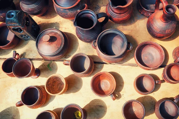 Top view of the clay dishes. Handmade products in the pottery workshop. Pots, jugs, mugs, goblets and vases of burnt ceramics.