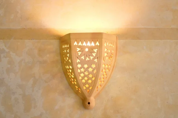 Yellow lamp in Arabic style. Wall lantern made of clay in a hotel in Tunisia in the middle East. Patterns on the wall lamp yellow.