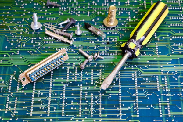 Screwdriver for electronics repair against circuit board