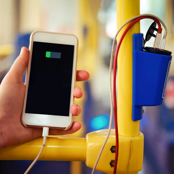 Charging the phone in transport. Connecting the phone with wires to charge the battery on the bus.