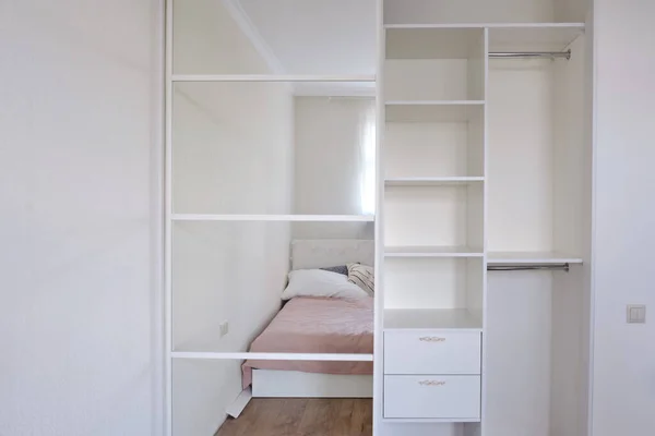 Built-in modern wardrobe with a mirror in the bedroom