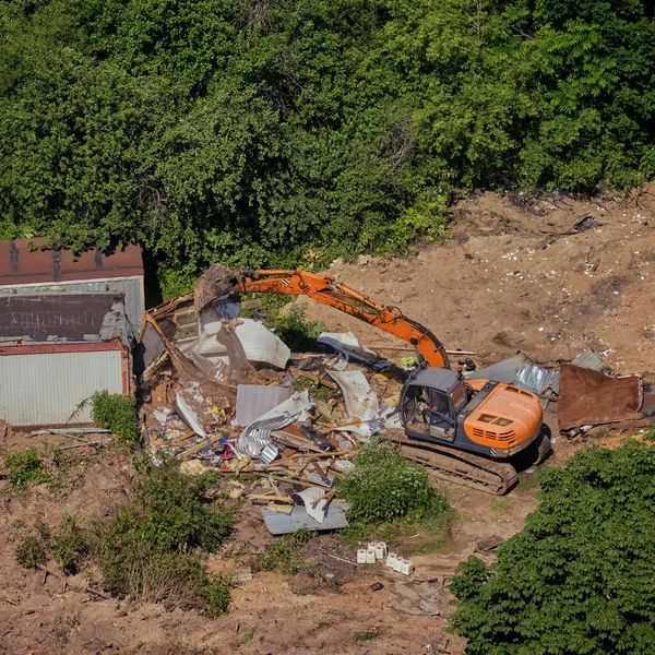 Destruction of an illegally constructed old building using an excavator