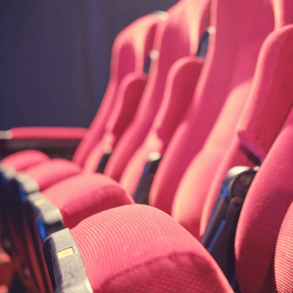 An empty row of chairs with no people in the auditorium. Problems during the coronavirus pandemic, concept with empty seats in cinema hall