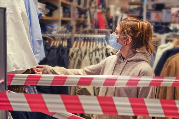 Adult female clerk in a closed store during quarantine due to the flu virus epidemic