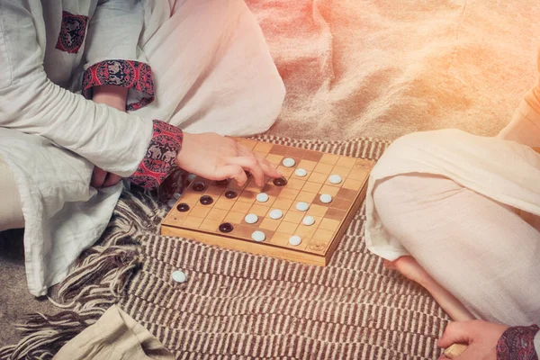 Tafl is a Scandinavian boardgame. Players at the Board game a retro style. Two men playing Hnefatafl, close-up.