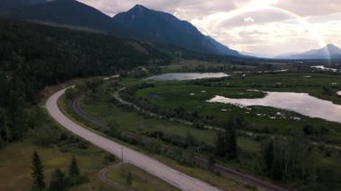 Aerial drone flight over scenic valley lake with rainbow