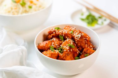 Biberli tavuk, arka planda pilav ile servis edilir.