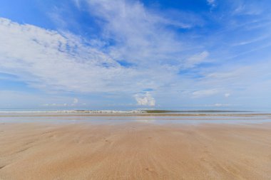 Deniz kum gökyüzü ve yumuşak kum plajındaki yaz günü mavi okyanus dalgası
