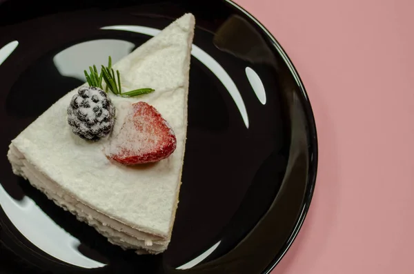 ブラックプレートのケーキのスライスピンクの背景 — ストック写真