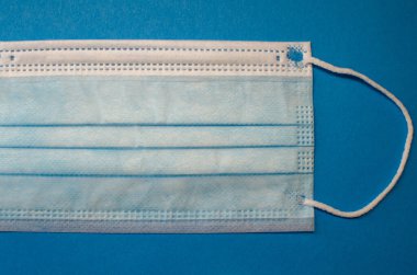 Mavi arka planda Coronavirus maskesi.