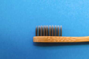 Mavi arkaplanda bambu diş fırçası, yakın plan..