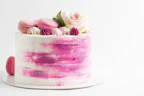 右側にコピースペースがある白い背景の上に花とマカロンと結婚式ピンクのケーキ — ストック写真