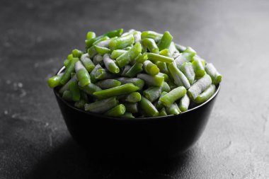 Yeşil fasulyeler parçalara ayrılıp siyah mermer masanın üzerindeki siyah kasede donduruldu. Filizlerin üzerinden..