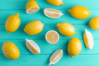 Turkuaz ahşap arka planda taze kesilmiş limonlar. Yukarıdan görüntüle