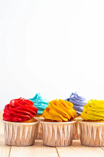 Cupcake Con Cime Panna Montata Colorate Foderate Fila Sullo Sfondo — Foto Stock