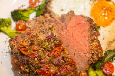 Kızarmış ve baharatlı et ve yanında kızarmış yumurta, brokoli, soğan ve domates..