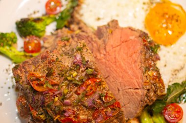 Kızarmış ve baharatlı et ve yanında kızarmış yumurta, brokoli, soğan ve domates..