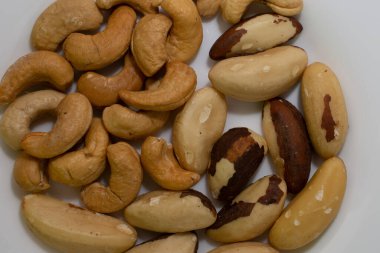 Beyaz bir tabakta kaju ve kavrulmuş Brezilya fındığı