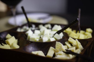 Gouda peynirli ahşap peynir tahtası, taze parmesan, parmesan peyniri ve siyah tepeli bir masada Gorgonzola.