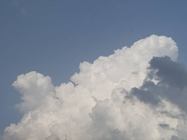 Mavi gökyüzünde beyaz ve siyah bulutlar