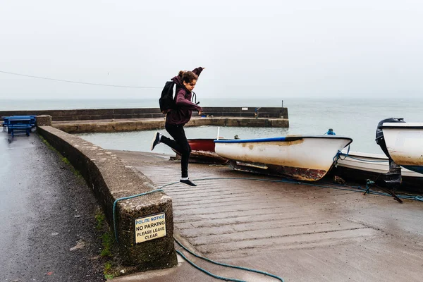 Nő alkalmi ruhában, ugrás a harbor ír Coast — Stock Fotó