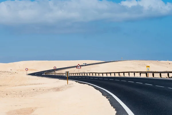 Scenic view of road through sand dunes against sky — Stock Photo, Image