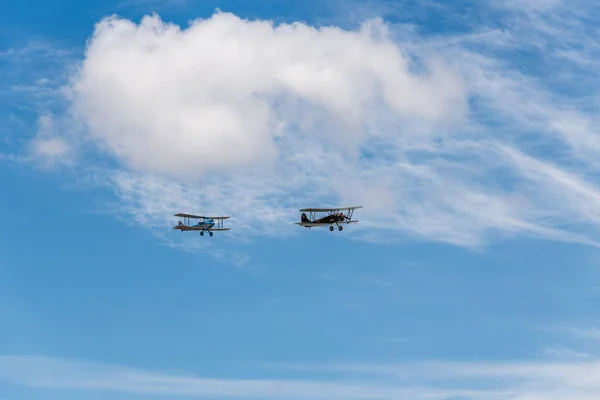 Formatie vliegen van twee oude dubbeldekker-vliegtuigen tijdens airshow — Stockfoto