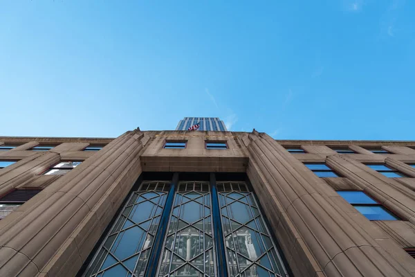 Nízký úhel pohled na Empire State Building a před americkou vlajkou — Stock fotografie