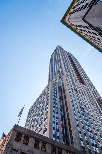 Lage hoek uitzicht op Empire State Building en de Amerikaanse vlag agains — Stockfoto