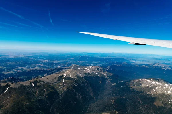Aerial view of landscape through airplane window against sky — Stock Photo, Image