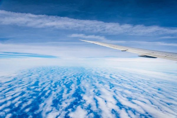 Aerial view of cloudscape through airplane window against sky — Stock Photo, Image