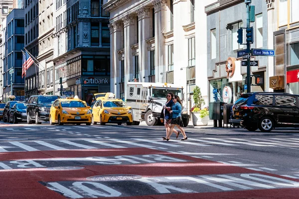 Persone che attraversano Fifth Avenue a New York con taxi gialli o — Foto Stock