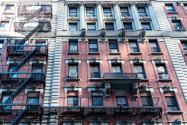 Low angle view of old apartment building with fire escape in Midtown of New York City