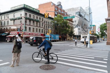 Kadın ve bisikletçi geçiş street New York için bekliyor