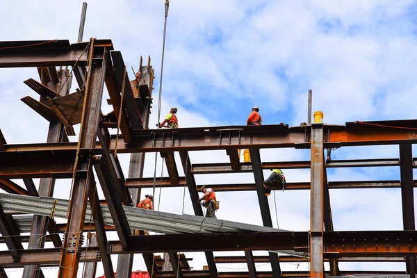 Travailleurs de la construction sur des poutres en acier sur le chantier de construction de ciels — Photo