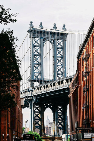 New York City, USA - June 20, 2018: Iconic view of the Manhattan Bridge framing the Empire State Building beneath, as seen from Washington Street