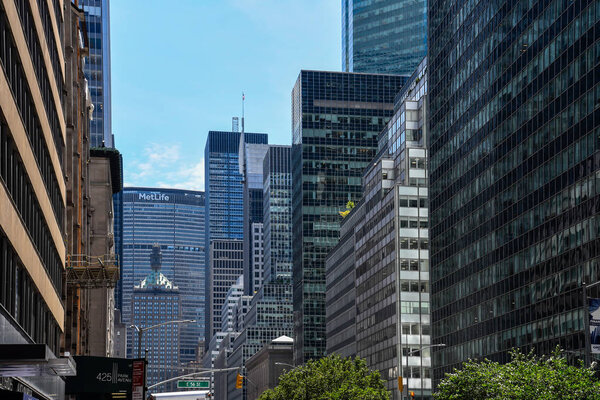 New York City, USA - June 21, 2018: Low angle view of Park Avenue in Manhattan with office buildings and MetLife building on background. Park Avenue is a wide New York City boulevard