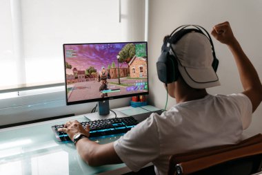 Teenager playing Fortnite video game on PC clipart