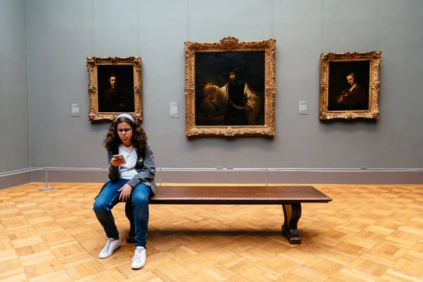 Müzesi resim salonunda bankta oturan kız — Stok fotoğraf